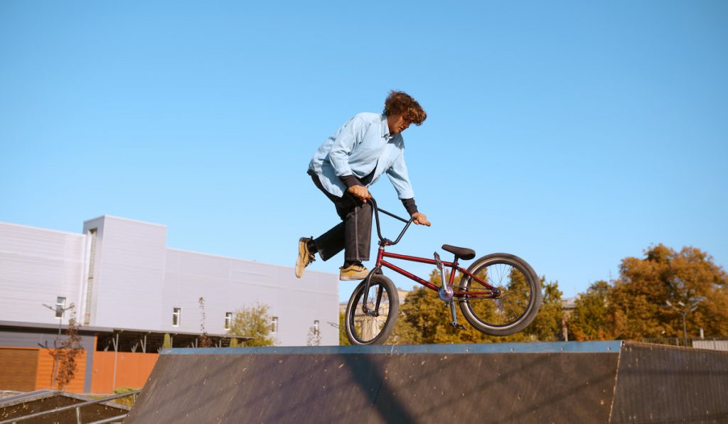 Bmx biker doing trick on ramp in skatepark

