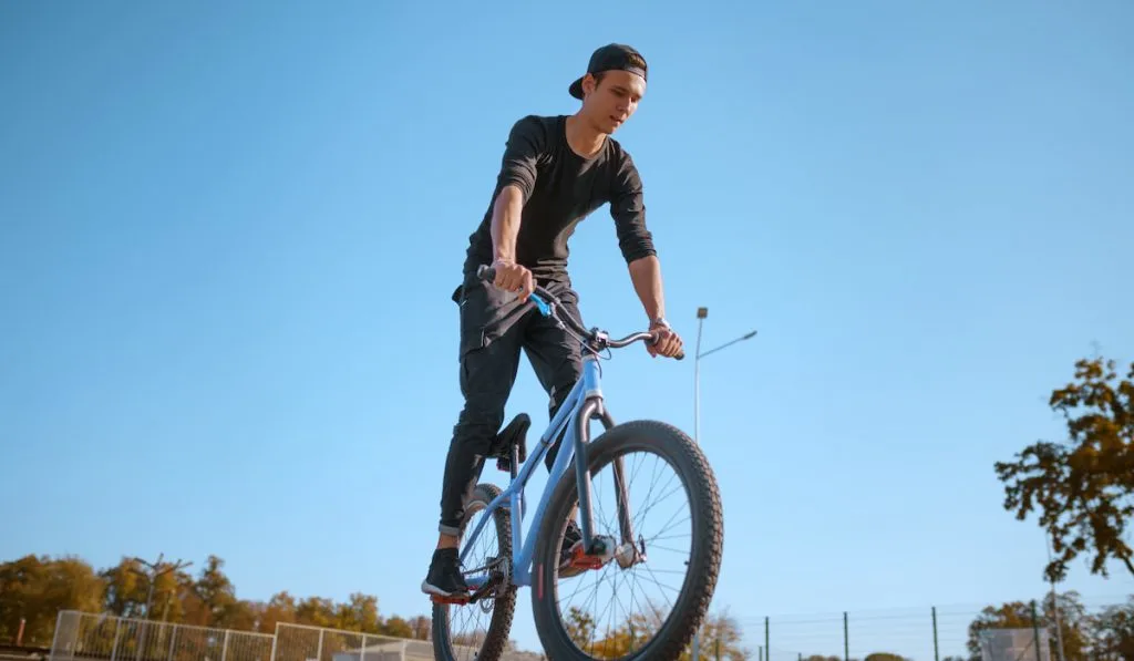 Male bmx biker, jump in action, skatepark
