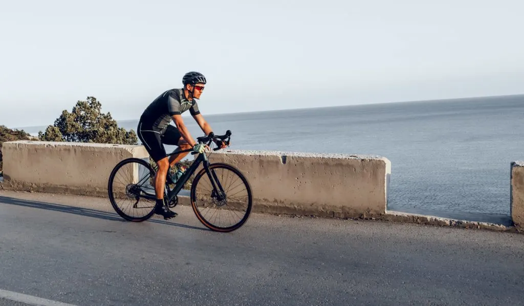 Man cyclist pedaling on a road bike outdoors