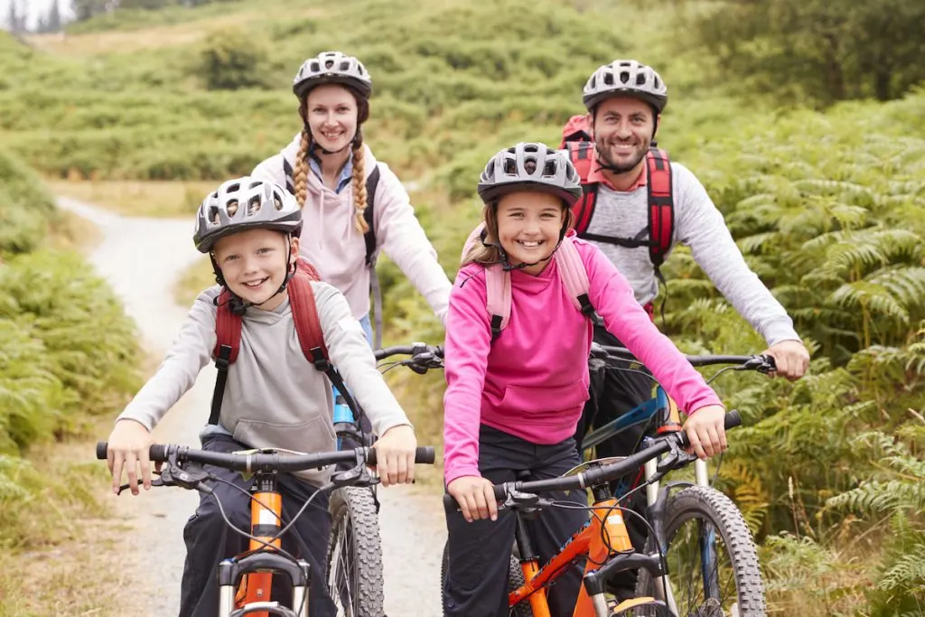 Portrait of parents and children sitting on mountain bikes