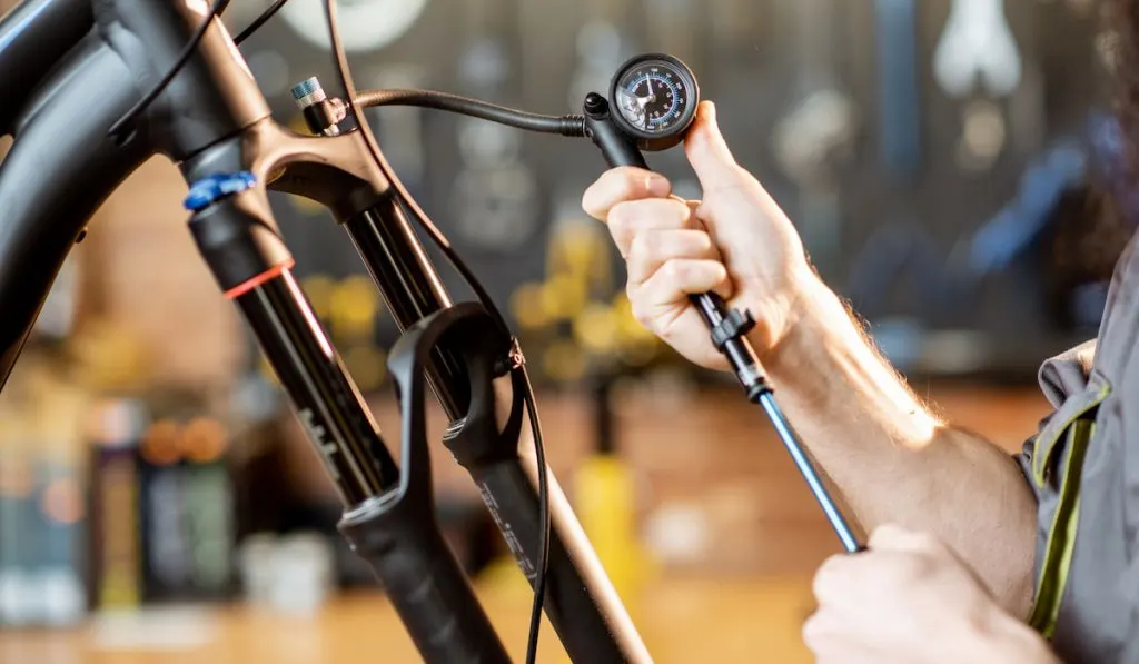 Repairman pumping bicycle fork at the workshop