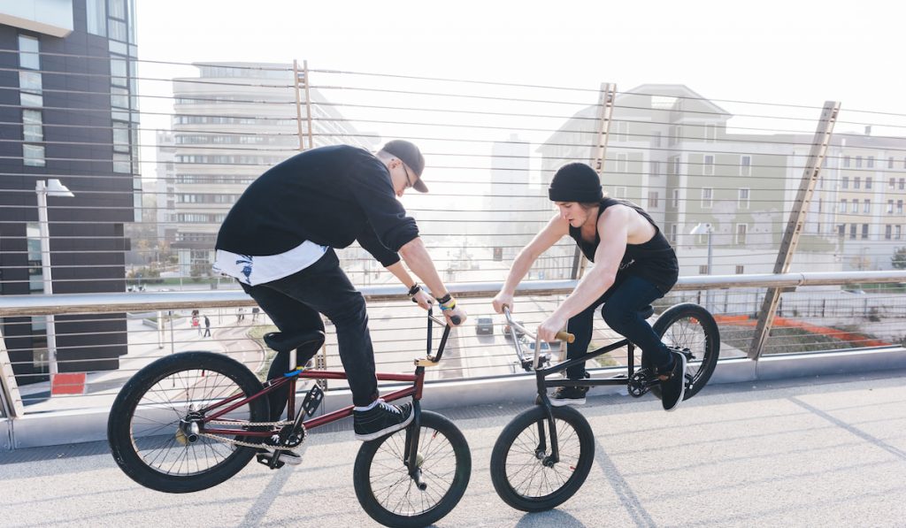 Two young guys jumping bmx on the bridge