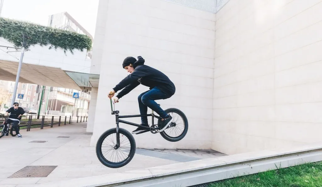 Young teenarger jumping and doing tricks with bmx bike