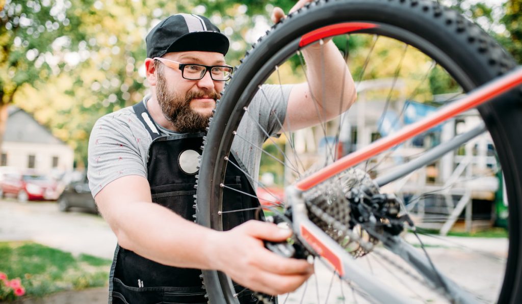 bicycle repairman working with bike wheel